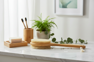Bambus badeprodukter i naturlige materialer, rent minimalistisk flat lay på hvidt baderumsunderlag, varmt lys – Bad | BIBAMBUS