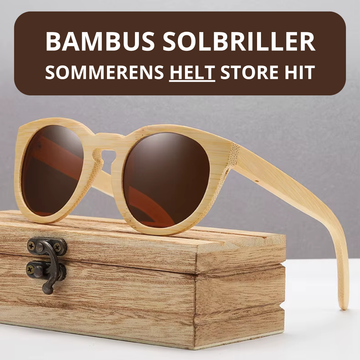 Runde bambus solbriller med brunt glas og lyst naturligt bambus stel hvilende på rustik træetui med metalhængsel – lifestyle-foto med teksten "BAMBUS SOLBRILLER – SOMMERENS HELT STORE HIT" – Bambus Solbriller | BIBAMBUS 'Round Me Up'