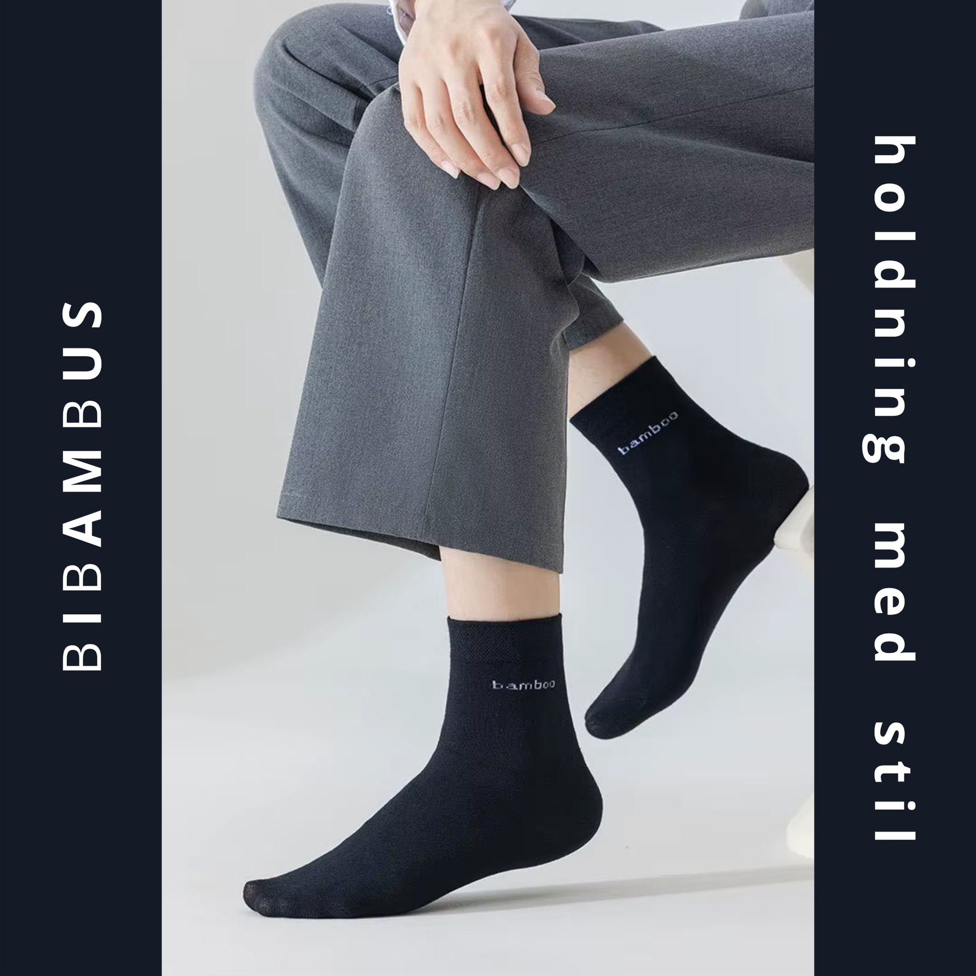 Sorte bambus strømper med bamboo-tekst båret af siddende person i grå bukser – lifestyle-foto med mørk grafisk ramme og BIBAMBUS branding – Bambus strømper | BIBAMBUS 'Lovely Bamboo Feet'