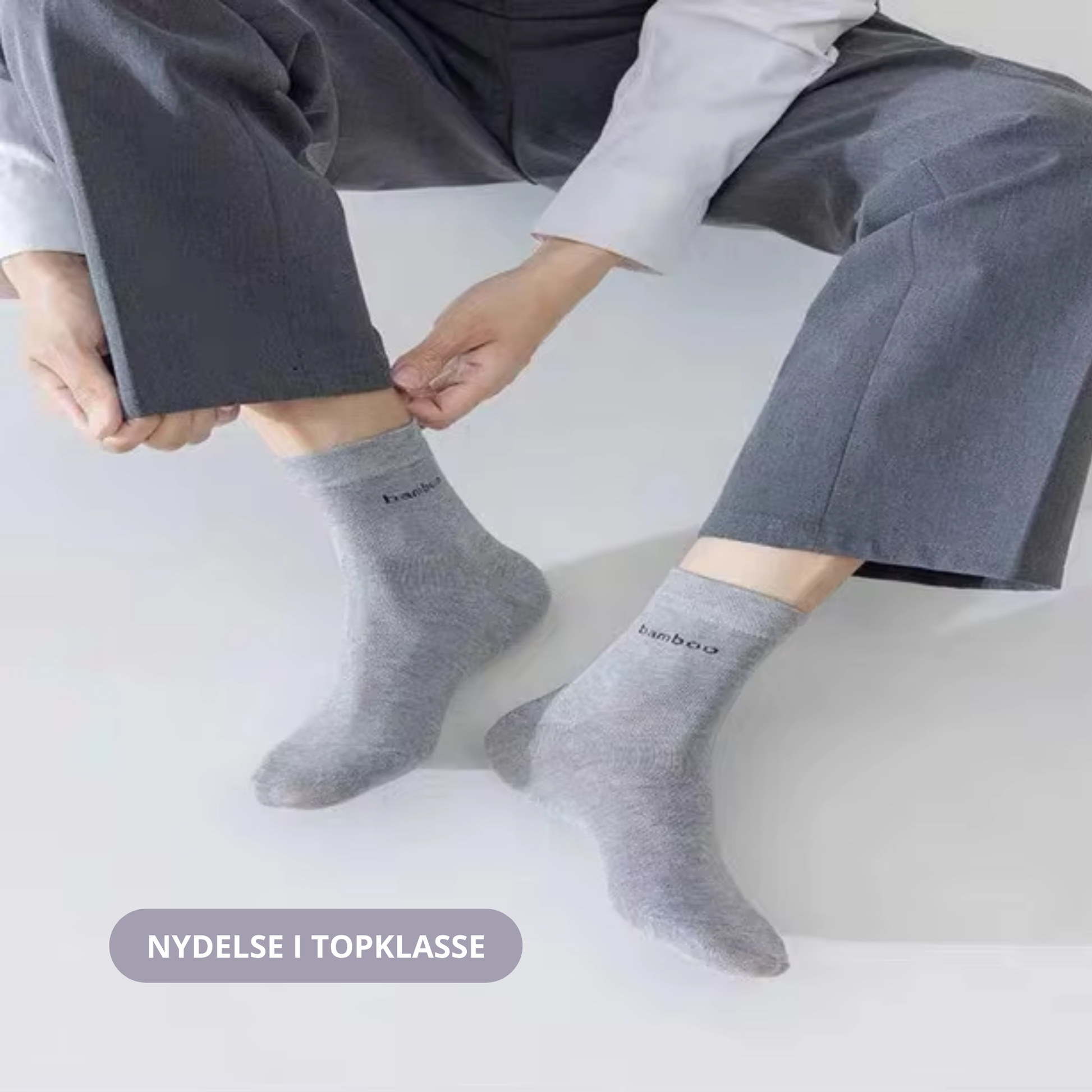 Lysegrå bambus strømper med bamboo-tekst båret af to personer siddende side om side på hvid baggrund – lifestyle-foto – Bambus strømper | BIBAMBUS 'Lovely Bamboo Feet'
