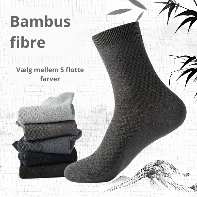 Mørkegrå bambusstrømpe med karakteristisk ternet rillestruktur mod japansk-inspireret baggrund med bambusblade og bjerge – fem foldede strømper i lysegrå, grå, mørkegrå, marineblå og sort stablet til venstre med teksten "Bambus fibre – Vælg mellem 5 flotte farver" – herrestrømper i bambusviskose str. 38-45 – Bambusstrømper til mænd | BIBAMBUS 'The Bamboo Gentleman'
