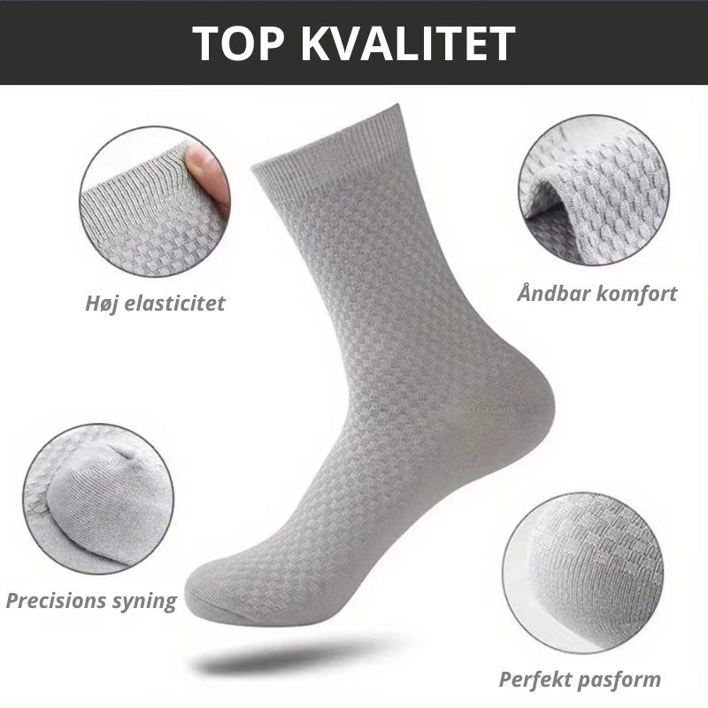 Lysegrå bambusstrømpe med fire nærbilleder der viser høj elasticitet, åndbar komfort, præcisions syning og perfekt pasform – infografik med teksten "TOP KVALITET" – herrestrømper i bambusviskose str. 38-45 – Bambusstrømper til mænd | BIBAMBUS 'The Bamboo Gentleman'